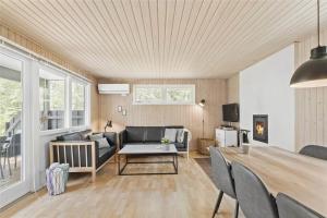 ein Wohnzimmer mit Sofa und Tisch in der Unterkunft 1583 Aakirkeby - Poserekrogen 8 in Vester Sømarken