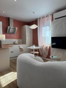 a kitchen and living room with a couch and a table at Appartement Le rêve de Gaïa Climatisation et Wifi in Moulins +19 photos