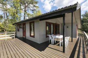 a house with a deck with a table and chairs at 1322-Aakirkeby-Malurtvej-10 in Vester Sømarken +14 photos
