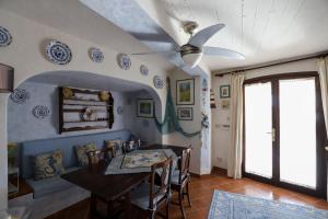 ein Esszimmer mit einem Tisch und einem Deckenventilator in der Unterkunft La Maison Bleue in Isola Rossa