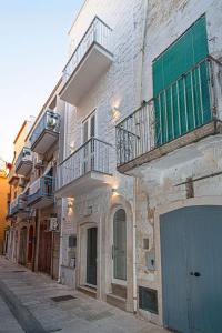 a building with balconies and a blue door on a street at Starry Sky House in Mola di Bari