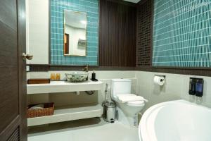 Un baño con inodoro, lavabo y espejo. en Soultel โซลเทล, en Khlong San 34 fotos más
