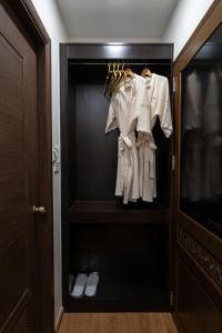 een kast met witte jassen en schoenen erin bij Soultel โซลเทล in Khlong San