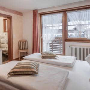 two beds in a room with a window at Die Sportbar in Rio Bianco