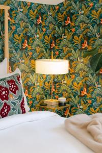 a bedroom with a green and orange floral wallpaper at Signature Balneary, Spa & Sauna in Deauville