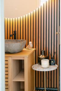 a bathroom with a sink and a wooden wall at Signature Balneary, Spa & Sauna in Deauville +13 photos