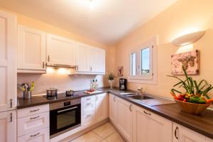 a kitchen with white cabinets and a sink at Luxuswohnung Sylt in Cala Ratjada