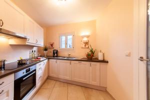 a kitchen with white cabinets and a sink at Luxuswohnung Sylt in Cala Ratjada +11 photos