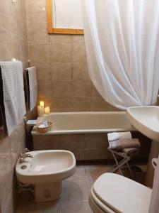 a bathroom with a toilet and a tub and a sink at Al 31 in Orvieto