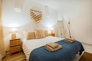 ein Schlafzimmer mit einem Bett mit Handtüchern darauf in der Unterkunft Stunning Apartment By Dreamplaces in Caliços + 15 Fotos