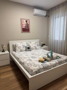 a white bedroom with a bed with a stuffed animal on it at Modern & Cosy Flat in Maniago! in Maniago