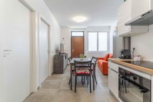 a kitchen and living room with a table and chairs at Dany & Carol - Affitto Breve Rho Stazione-Milano in Rho