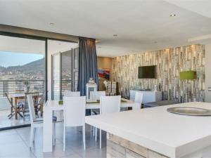 a dining room with a white table and white chairs at Mandela Rhodes Place in Cape Town