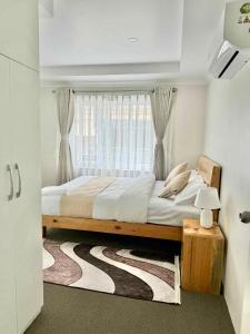 a bedroom with a large bed with a window at Peaceful 2BHK, Near Thamel & Swayambhu in Kathmandu