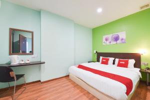 a bedroom with a large bed and a mirror at Dancenter G Home Hotel in Kota Bharu