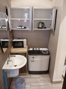 une petite cuisine avec un évier et une cuisinière dans l'établissement Masa Residences-شقق الماسة, à Médine 5 autres photos