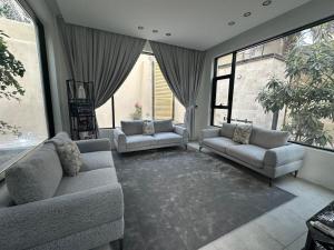 sala de estar con 2 sofás y ventanas grandes en عذوق, 