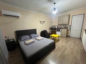 a small bedroom with a bed and a kitchen at BMG (Be My Guest) in Mtskheta