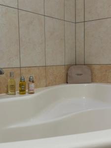 a bath tub with two bottles of essential oils on it at Karol-ina Estate in Branik +15 photos