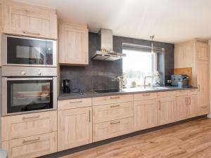 a kitchen with wooden cabinets and a sink and a window at Ferienhaus in Amelgatzen mit Terrasse in Emmerthal