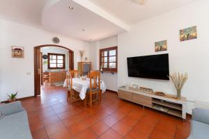 sala de estar con mesa y TV de pantalla plana en Vivelorural Los Tableros Agaete great terrace, en Agaete