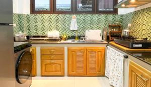 Una cocina con gabinetes de madera y un fregadero. en Per La Villa Khao Lak, en Khao Lak