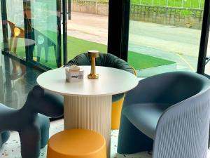 una mesa blanca y sillas con una botella. en S Club & Hotel, en Jomtien Beach 61 fotos más