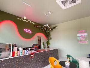 Un restaurante con un mostrador con una pared rosa y verde. en S Club & Hotel, en Jomtien Beach