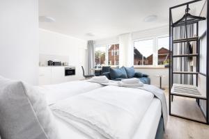 a bedroom with two white beds and a blue couch at Apartments in der Kurgartenstraße - Altstadt - An der Vorderreihe in Travemünde