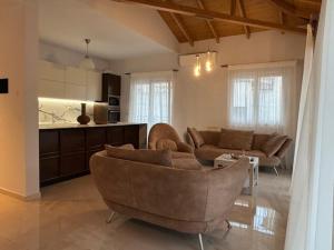 a living room with two couches and a kitchen at Irida Home in Parga +2 photos