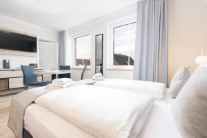 トラフェミュンデにあるApartments in der Kurgartenstraße - Altstadt - An der Vorderreiheの白いベッドルーム(大型ベッド1台、デスク付)