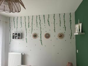 a wall with green decorations on a wall at Chambre Eucalyptus dans maison neuve in Bazainville +2 photos