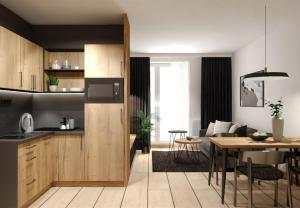 a kitchen and a living room with a table at Galleria Central Apartments & Wellness in Vrchlabí