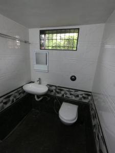 a bathroom with a sink and a toilet and a window at Enclave Villa 4BHK in Lonavala