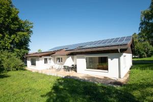 une maison avec des panneaux solaires sur le toit dans l'établissement Ferienhaus Wieselweg im Feriendorf Reichenbach 5, à Nesselwang 12 autres photos
