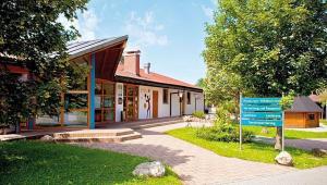 un bâtiment avec un panneau bleu devant lui dans l'établissement Ferienhaus Wieselweg im Feriendorf Reichenbach 5, à Nesselwang