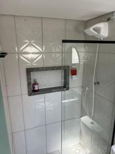 a white bathroom with a shower and a toilet at Suíte aconchegante no coração da Cidade in Sidrolândia