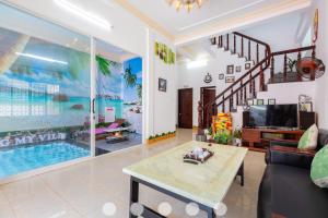 a living room with a tv and a pool at Villages Sân BBQ Cạnh Hồ Bơi Đường Võ Thị Sáu in Vung Tau