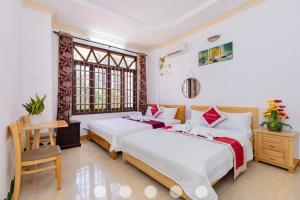 a bedroom with two beds and a desk and windows at Villages Sân BBQ Cạnh Hồ Bơi Đường Võ Thị Sáu in Vung Tau +31 photos