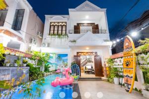a house with a pool with a pink flamingo in front of it at Villages Sân BBQ Cạnh Hồ Bơi Đường Võ Thị Sáu in Vung Tau