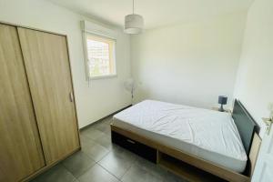 a bedroom with a bed and a sliding door at Nice 60m With Terrace In Ajaccio in Ajaccio