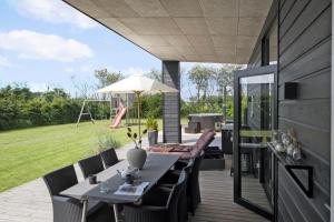 a patio with a table and chairs and an umbrella at OH306-Hadsund-Ridestien-3 in Hadsund