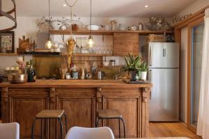 a kitchen with wooden cabinets and a white refrigerator at Ciasa TRI - Wellness Chalet in Vodo Cadore