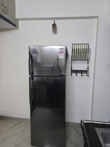 een zwarte koelkast in een keuken naast een muur bij 3BHK Flat Rudrashakti Enclave Nagpur in Nagpur