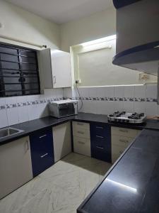 een keuken met een wastafel en een fornuis. bij 3BHK Flat Rudrashakti Enclave Nagpur in Nagpur