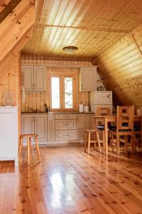 a kitchen with wooden ceilings and a table and chairs at Domek w Krasnobrodzie Pszczeliniec Krasnodomki in Krasnobród