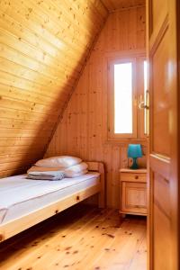 a bedroom with a bed in a wooden room at Domek w Krasnobrodzie Pszczeliniec Krasnodomki in Krasnobród