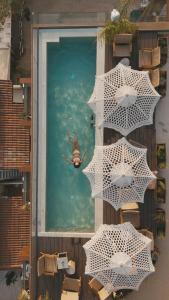 a person in the water in a pool with umbrellas at Saint Nicolas Hotel in Himare