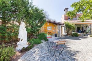 a statue in the middle of a courtyard with chairs at Refúgio das Artes Guesthouse in Porto de Mós