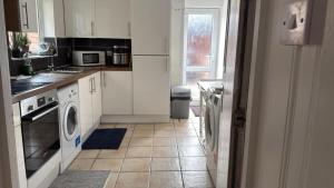 a kitchen with a washer and dryer in it at Lovely Room 3 in Avonmouth